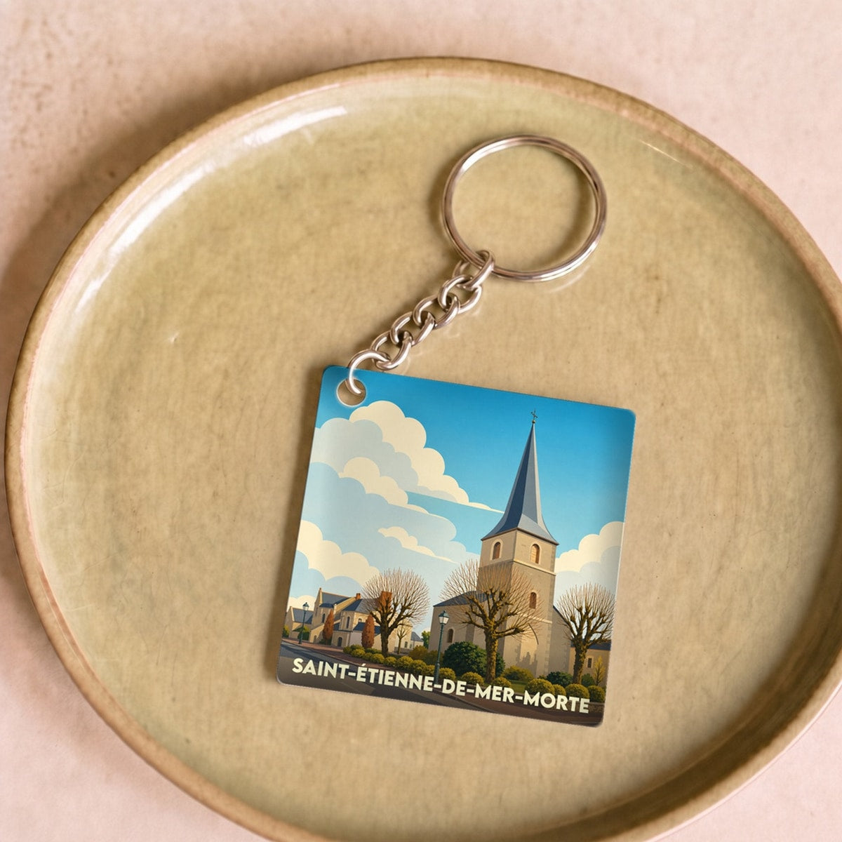 Porte-clés souvenir de la ville de Saint-Étienne-de-Mer-Morte avec une illustration stylisée de son église.