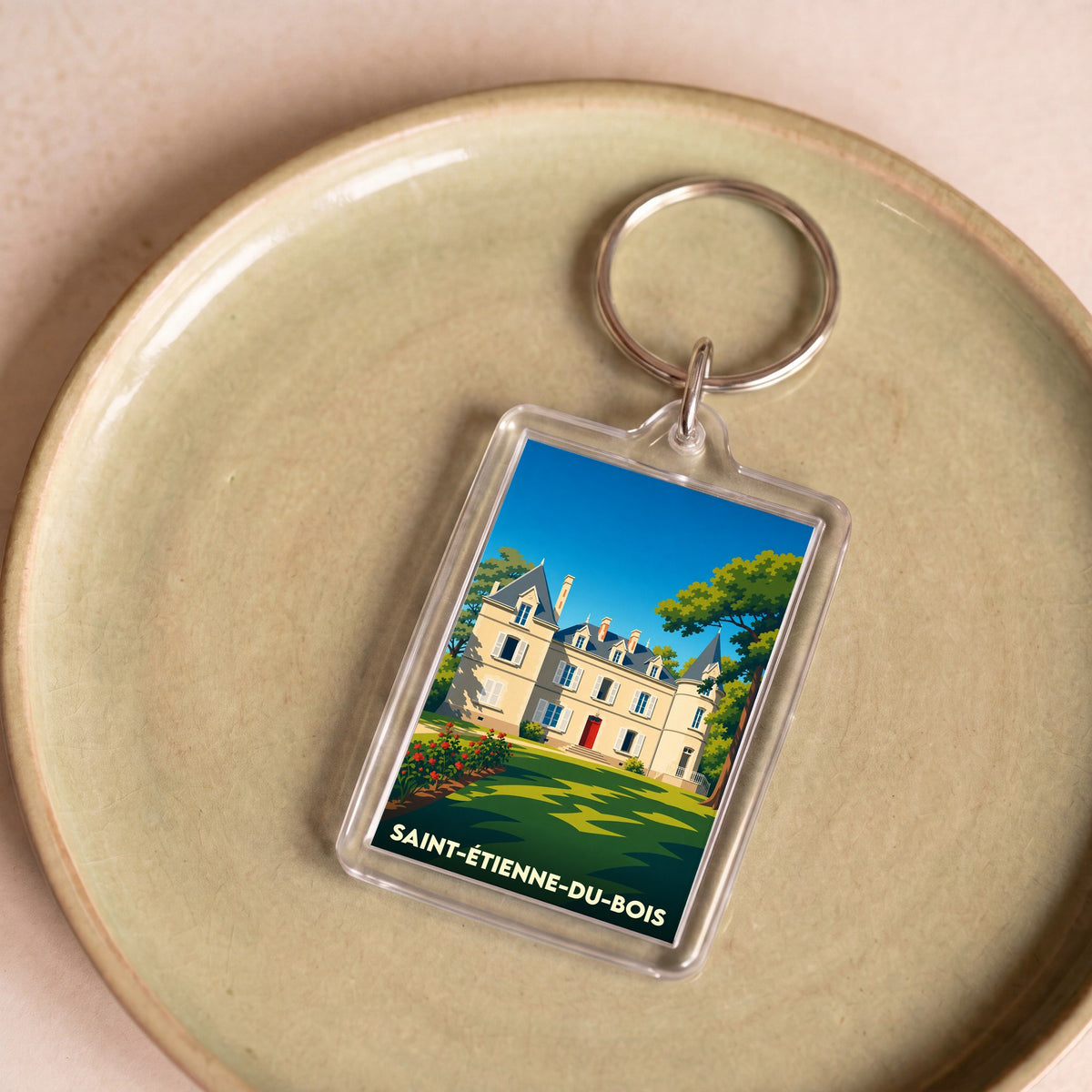 Porte-clés souvenir de la ville de Saint-Étienne-du-Bois avec une illustration stylisée d'un château.