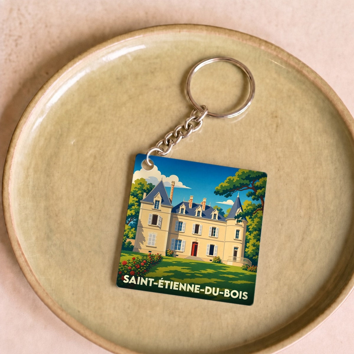 Porte-clés souvenir de la ville de Saint-Étienne-du-Bois avec une illustration stylisée d'un château.