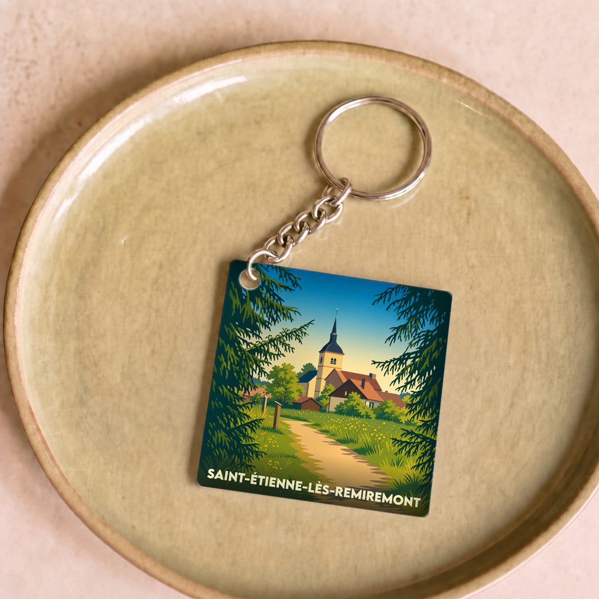Porte-clés souvenir de la ville de Saint-Étienne-lès-Remiremont avec une illustration stylisée.