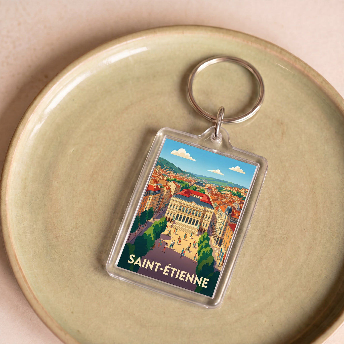 Porte-clés souvenir de la ville de Saint-Étienne avec une illustration stylisée.