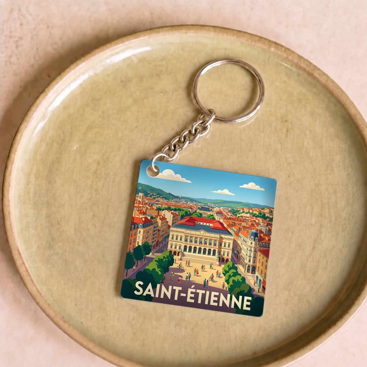 Porte-clés souvenir de la ville de Saint-Étienne avec une illustration stylisée.