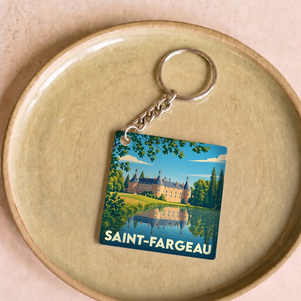 Porte-clés souvenir de la ville de Saint-Fargeau avec une illustration stylisée de son château et de son étang.
