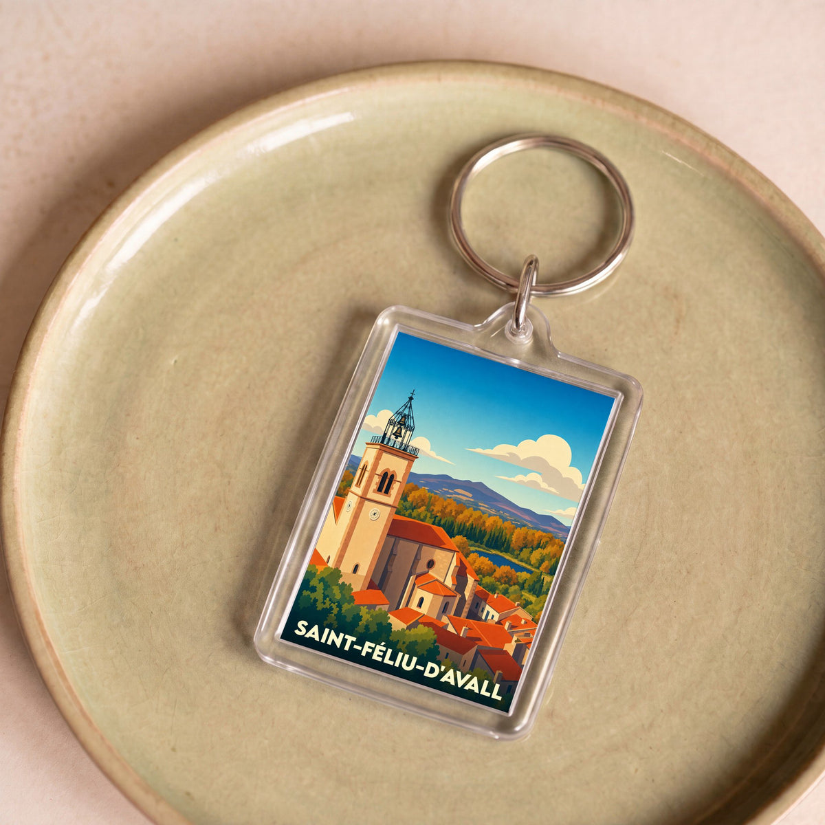 Porte-clés souvenir de la ville de Saint-Féliu-d'Avall avec une illustration stylisée.