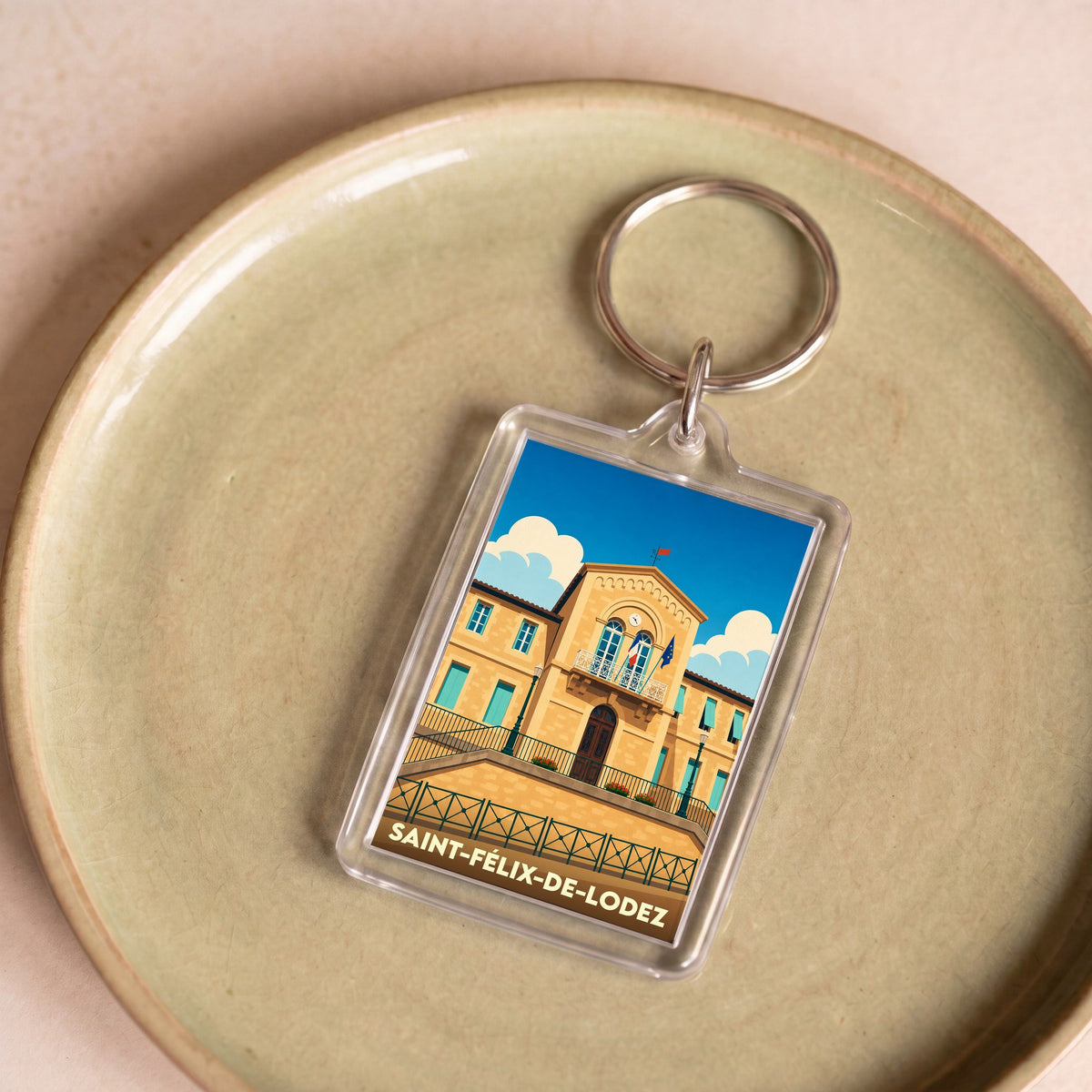 Porte-clés souvenir de la ville de Saint-Félix-de-Lodez avec une illustration stylisée de sa mairie.