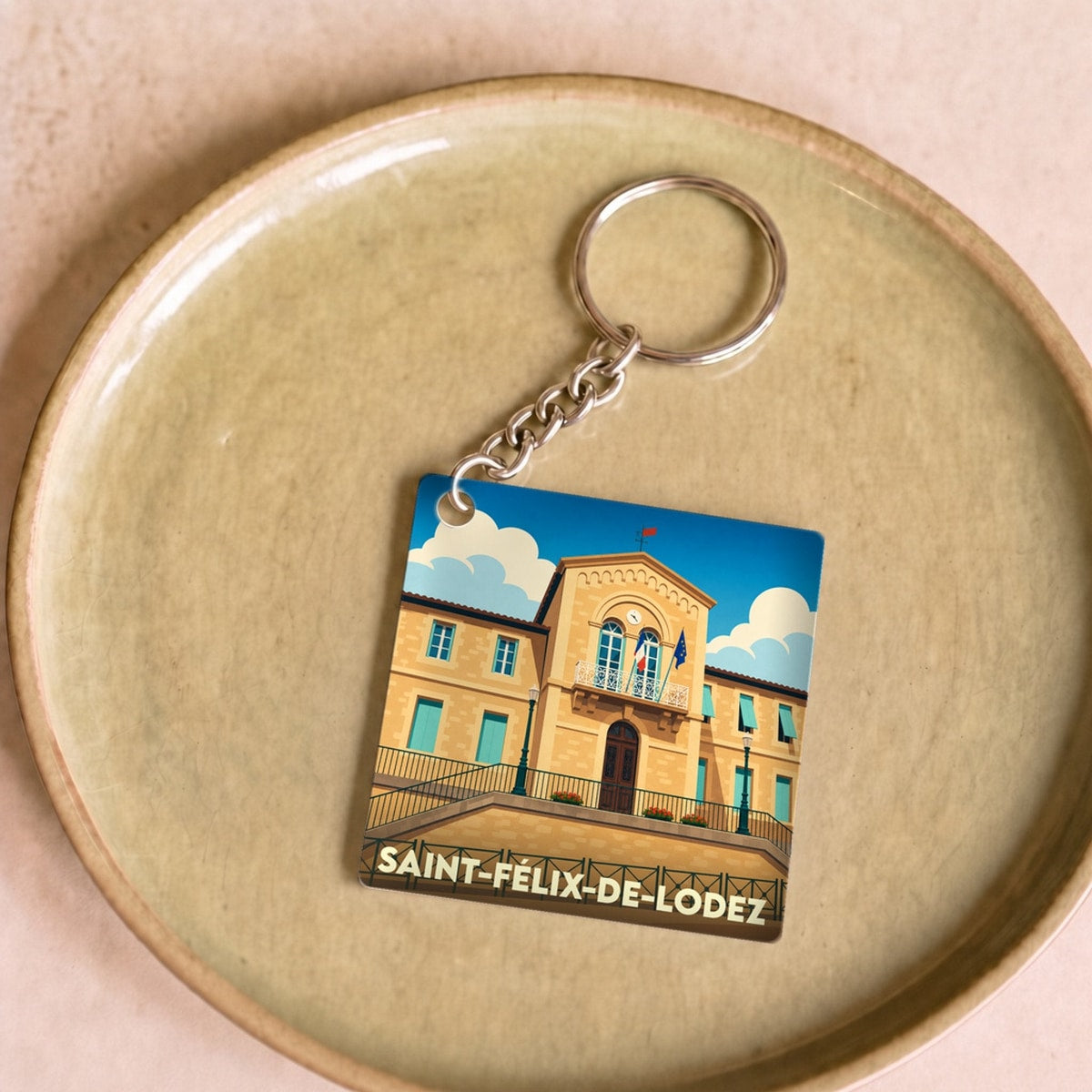 Porte-clés souvenir de la ville de Saint-Félix-de-Lodez avec une illustration stylisée de sa mairie.