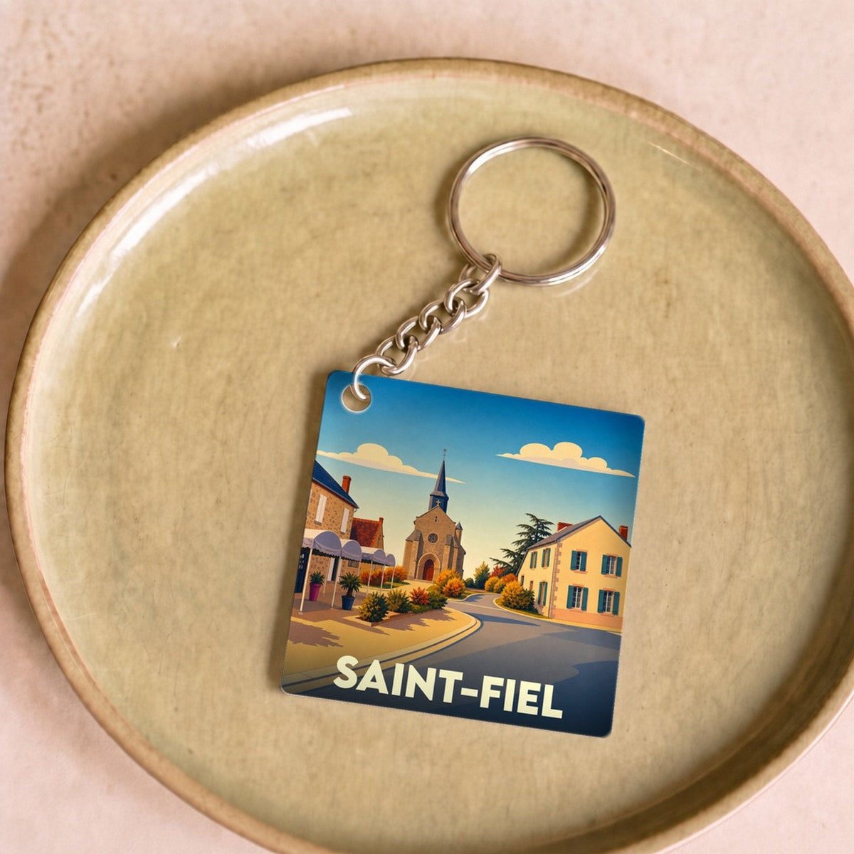 Porte-clés souvenir de la ville de Saint-Fiel avec une illustration stylisée.