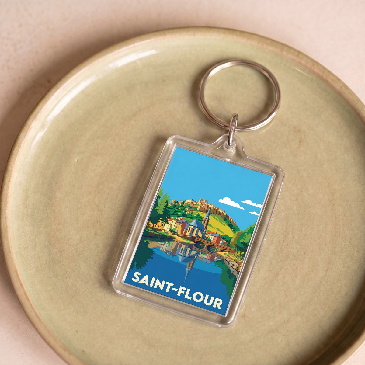 Porte-clés souvenir de la ville de Saint-Flour avec une illustration stylisée et colorée.