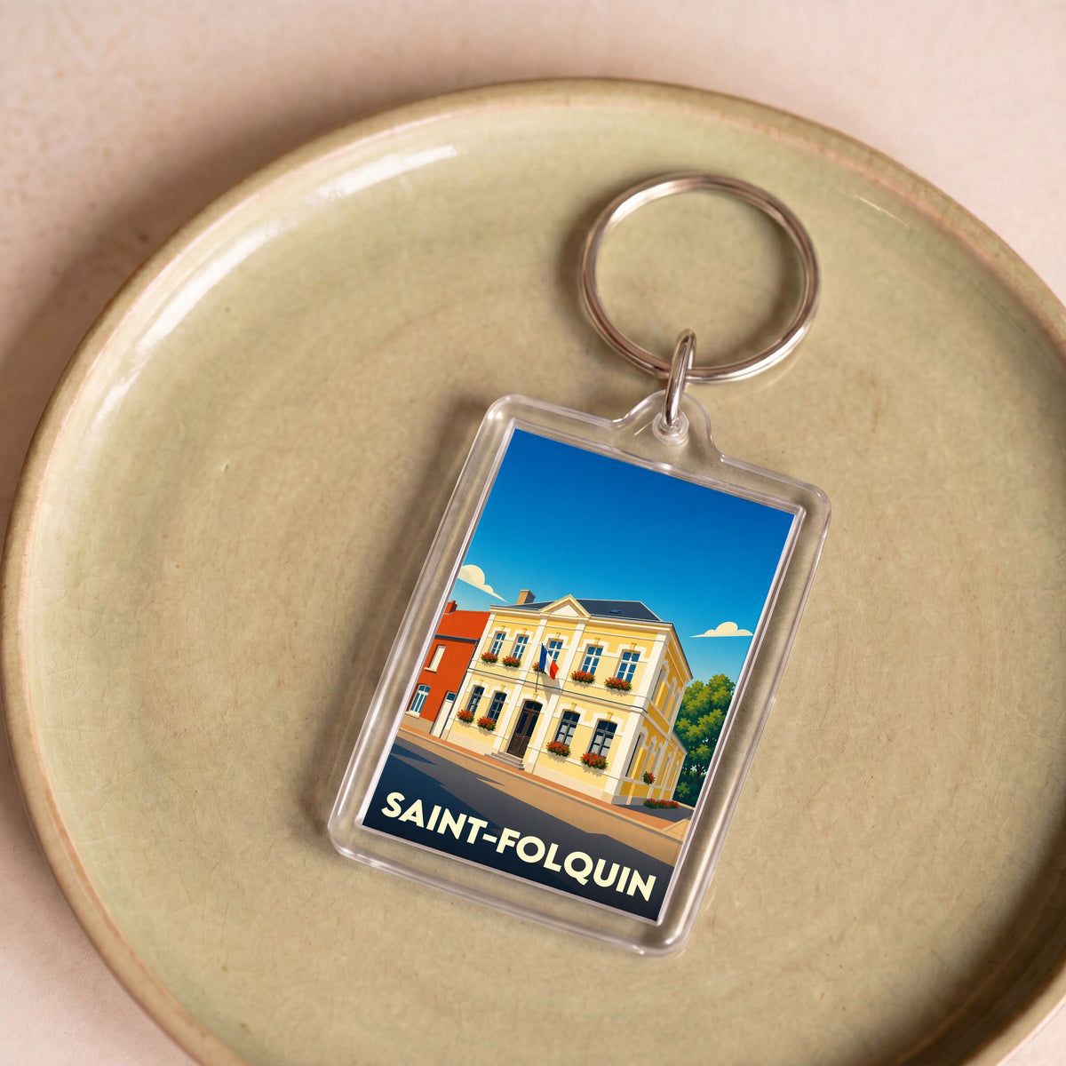 Porte-clés souvenir de la ville de Saint-Folquin avec une illustration stylisée de sa mairie.