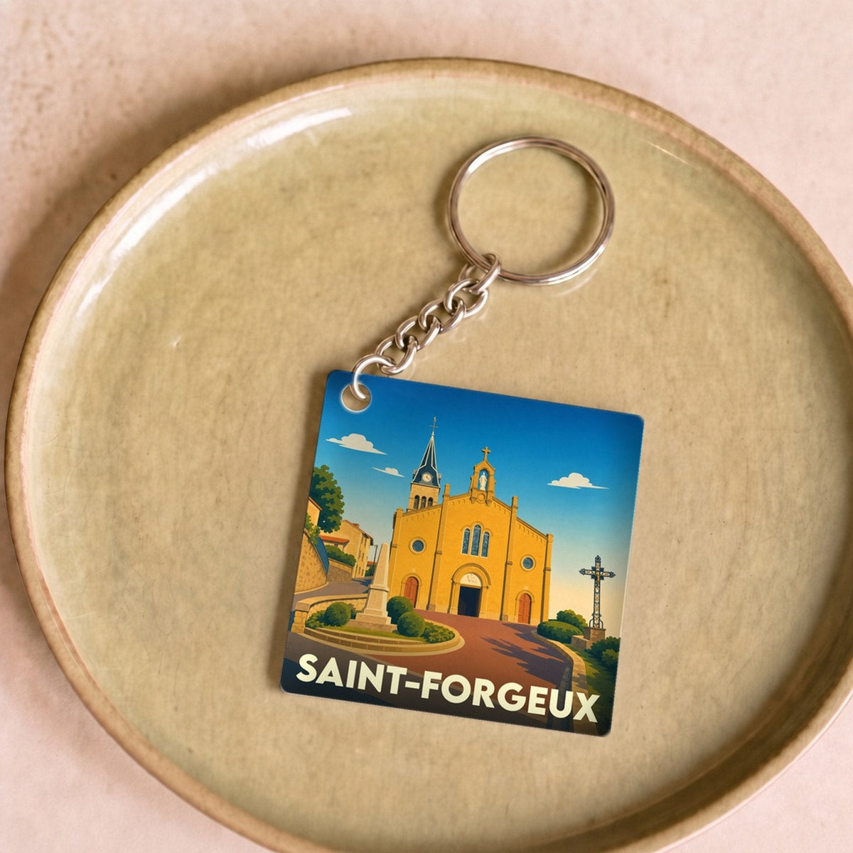 Porte-clés souvenir de la ville de Saint-Forgeux avec une illustration stylisée de son église.