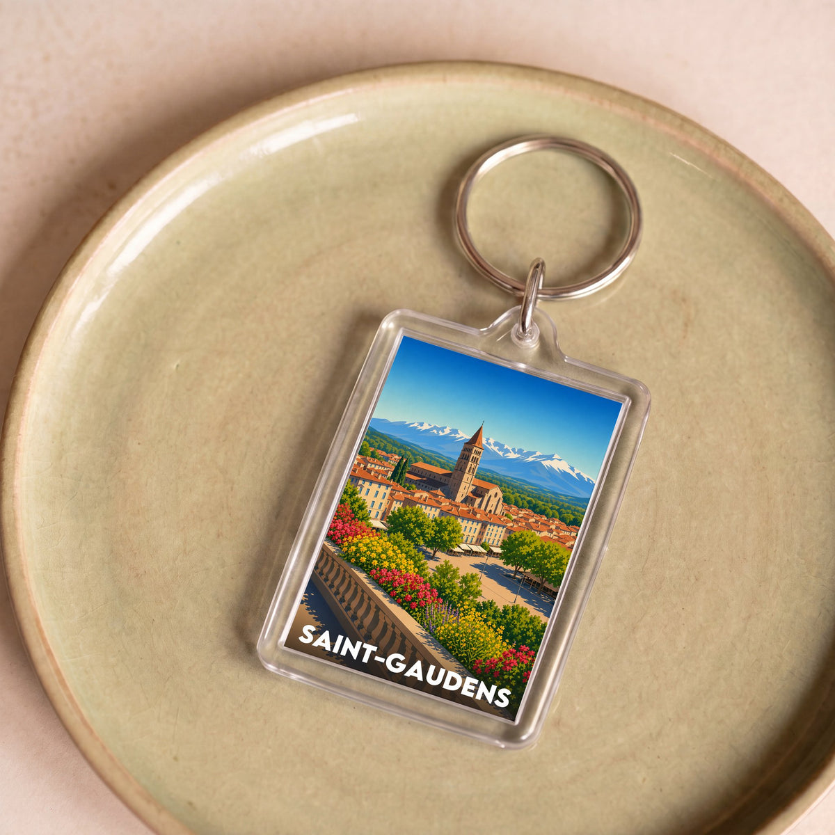 Porte-clés souvenir de la ville de Saint-Gaudens avec une illustration stylisée.
