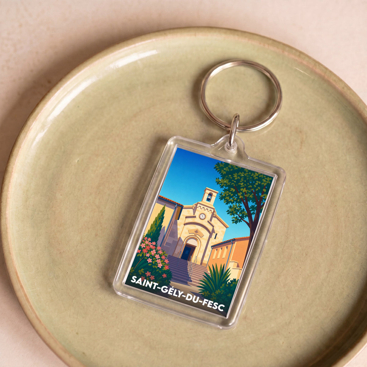 Porte-clés souvenir de la ville de Saint-Gély-du-Fesc avec une illustration stylisée de son église.