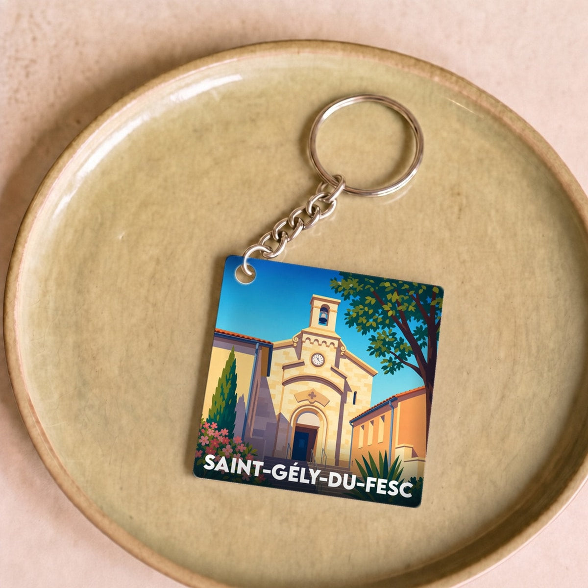 Porte-clés souvenir de la ville de Saint-Gély-du-Fesc avec une illustration stylisée de son église.