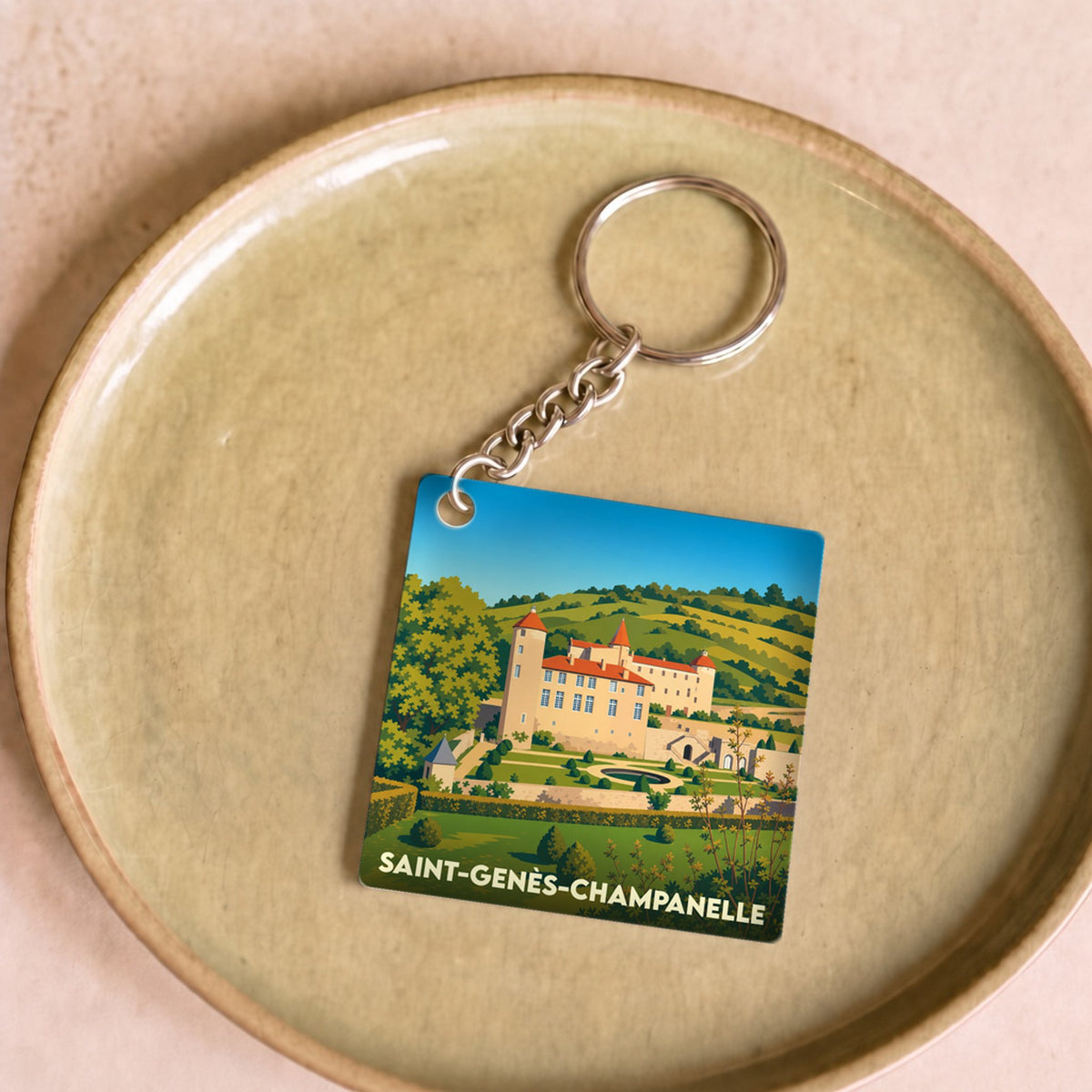 Porte-clés souvenir de la ville de Saint-Genès-Champanelle avec une illustration stylisée de son château.