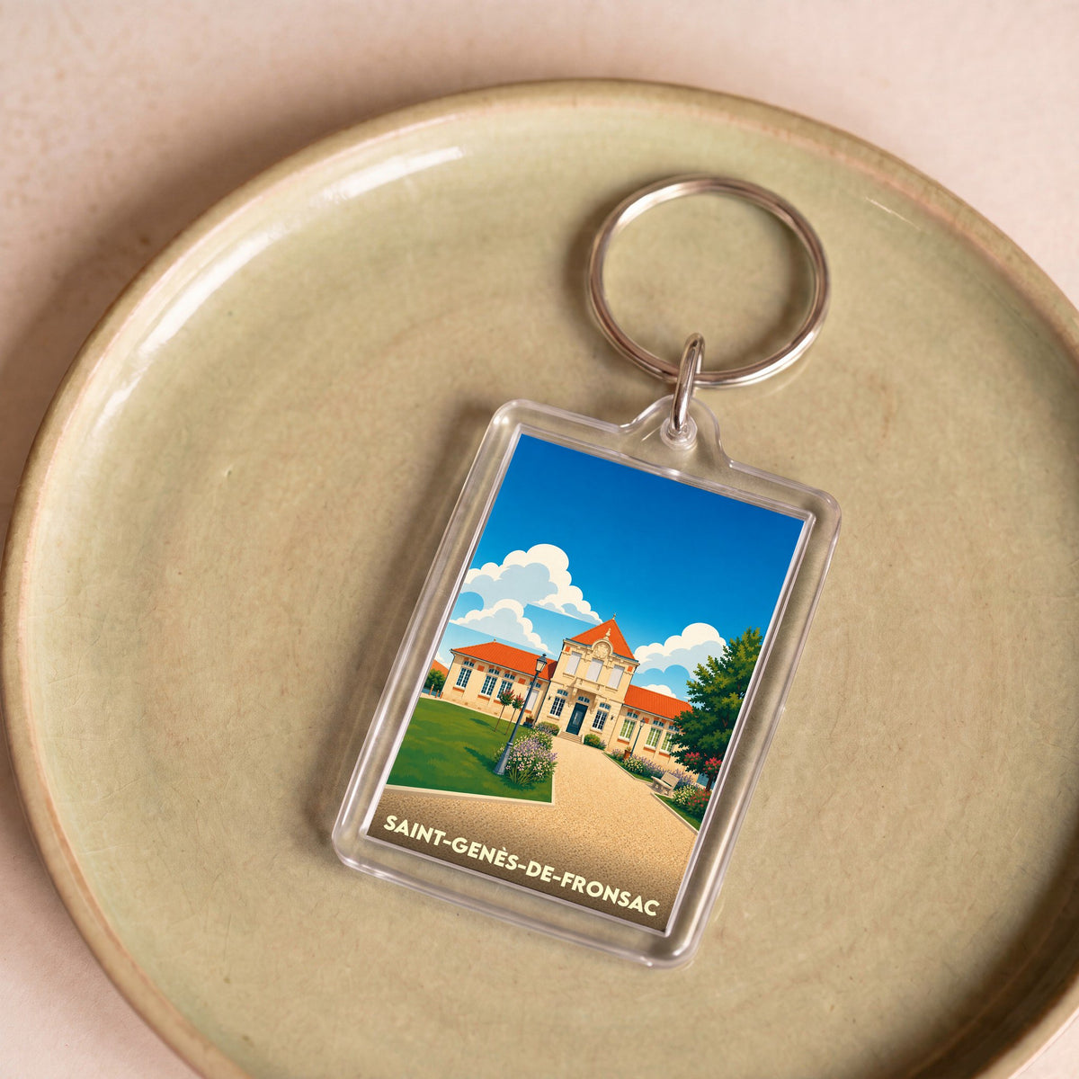 Porte-clés souvenir de la ville de Saint-Genès-de-Fronsac avec une illustration stylisée.