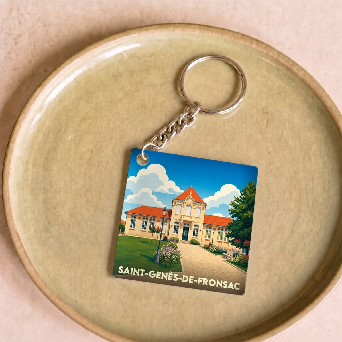 Porte-clés souvenir de la ville de Saint-Genès-de-Fronsac avec une illustration stylisée.