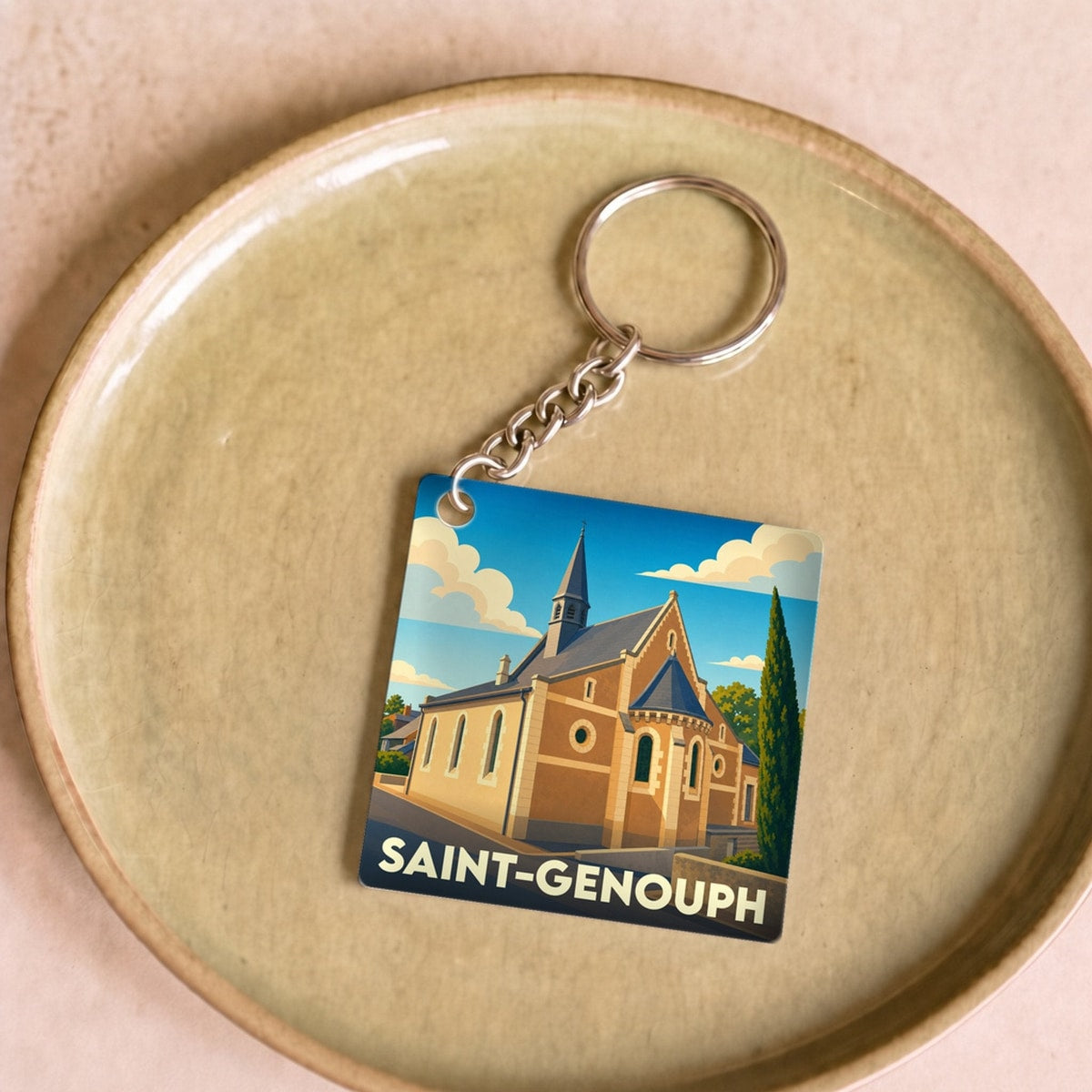 Porte-clés souvenir de la ville de Saint-Genouph avec une illustration stylisée d'une église.