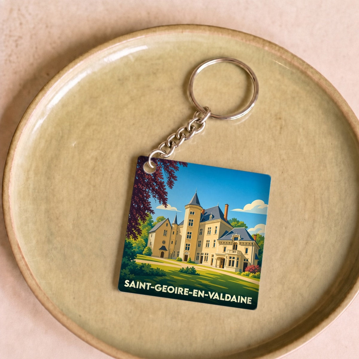 Porte-clés souvenir de la ville de Saint-Geoire-en-Valdaine avec une illustration stylisée d'un château.
