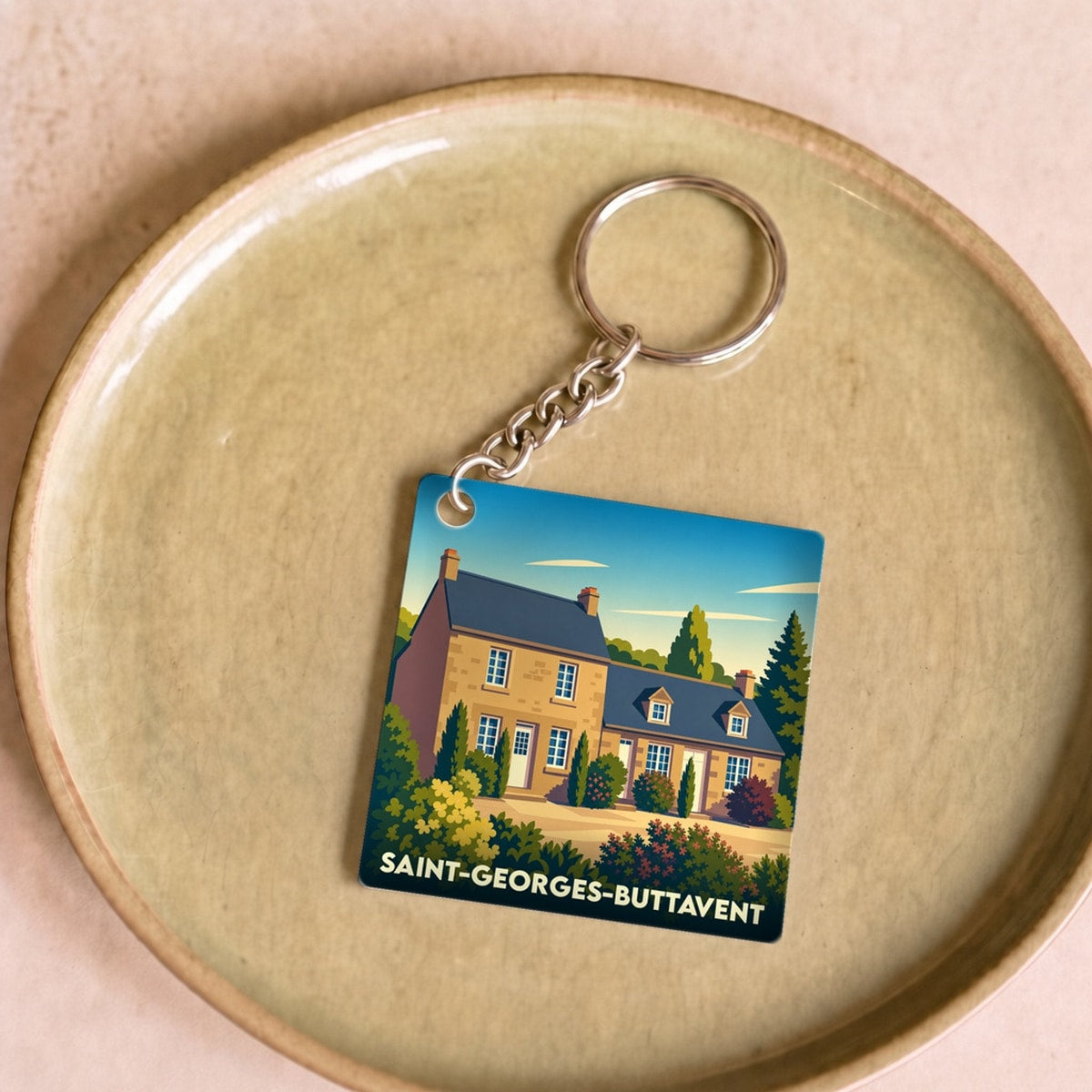 Porte-clés souvenir de la ville de Saint-Georges-Buttavent avec une illustration stylisée.
