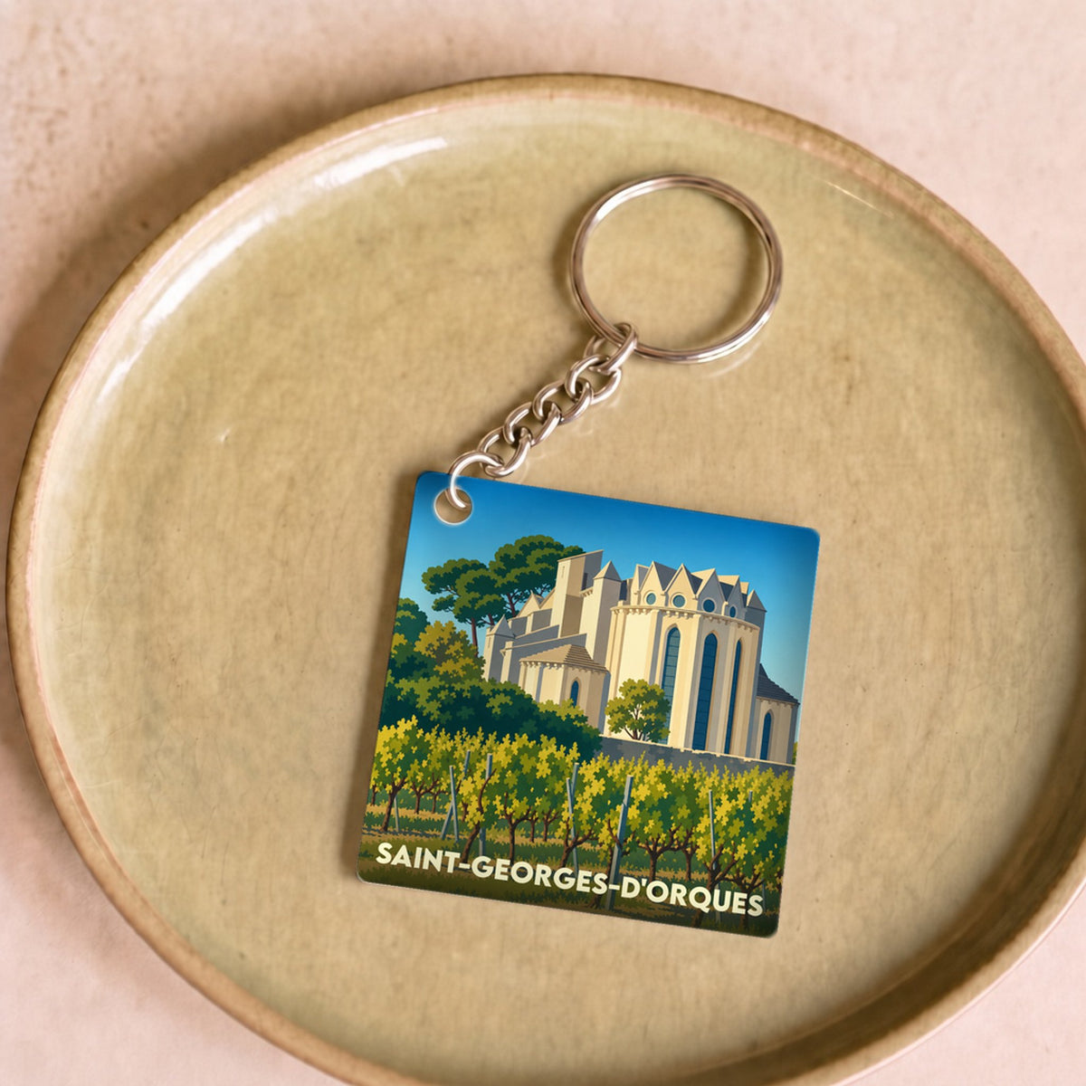 Porte-clés souvenir de la ville de Saint-Georges-d'Orques avec une illustration stylisée.