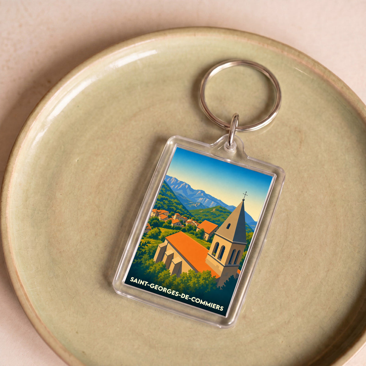 Porte-clés souvenir de la ville de Saint-Georges-de-Commiers avec une illustration stylisée.