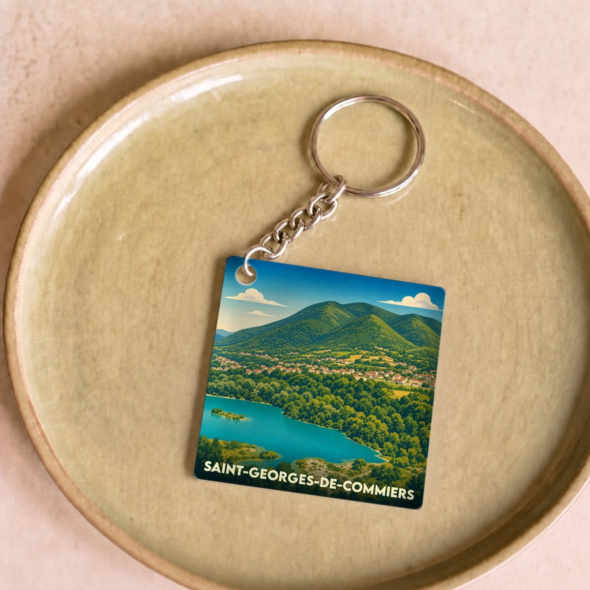 Porte-clés souvenir de la ville de Saint-Georges-de-Commiers avec une illustration stylisée.