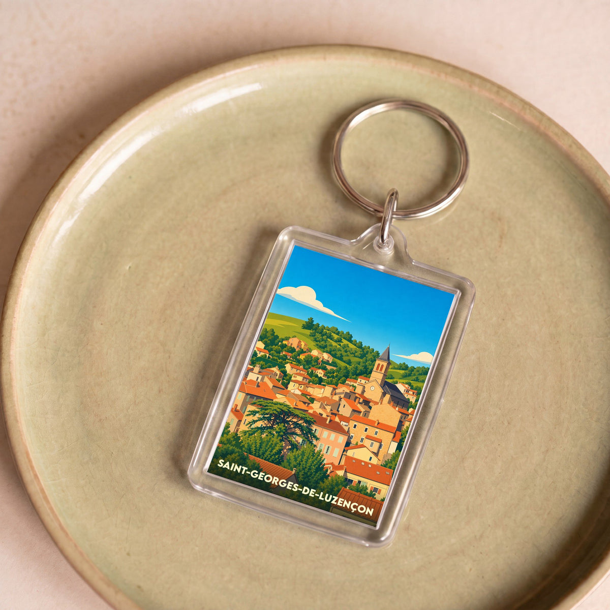 Porte-clés souvenir de la ville de Saint-Georges-de-Luzençon avec une illustration stylisée.