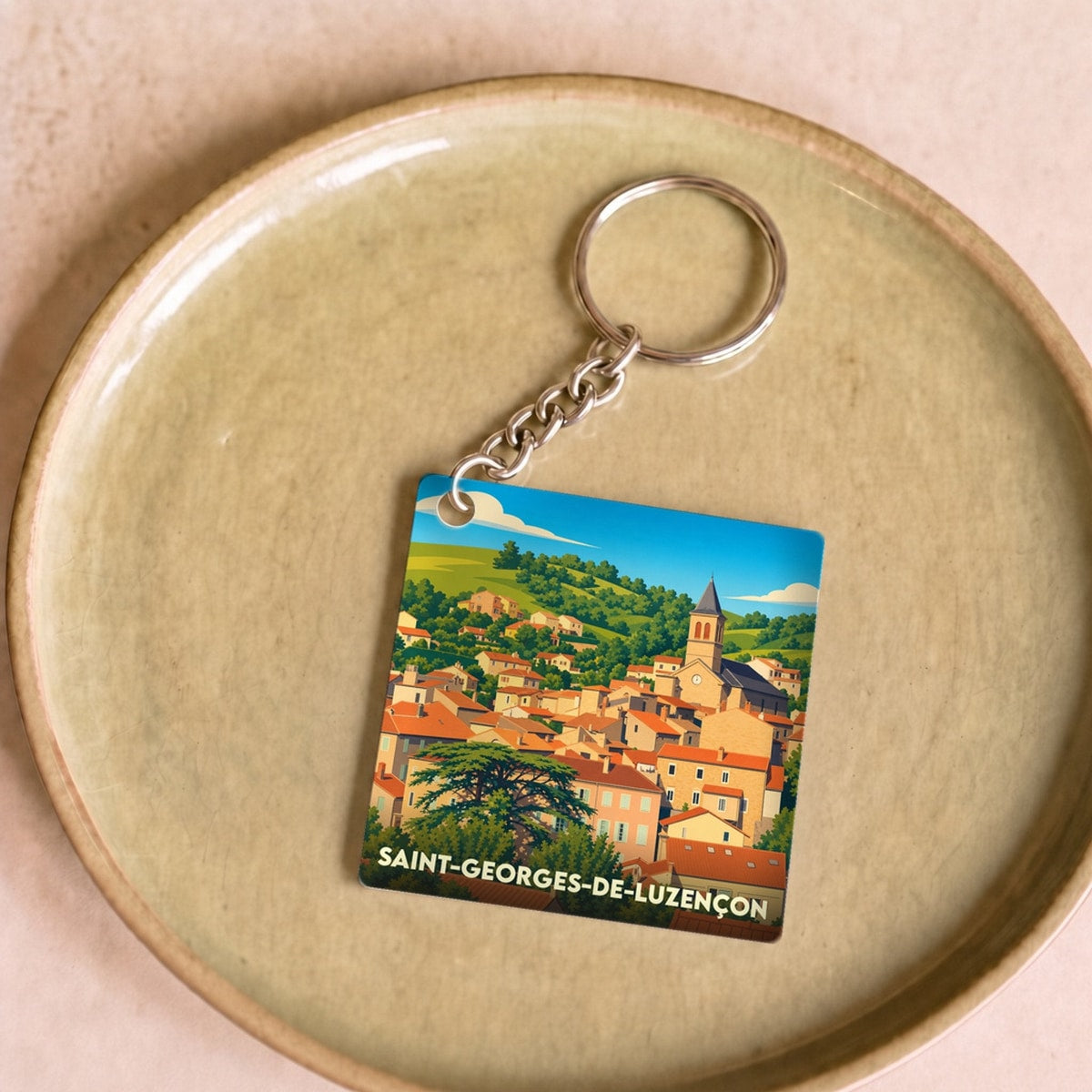 Porte-clés souvenir de la ville de Saint-Georges-de-Luzençon avec une illustration stylisée.
