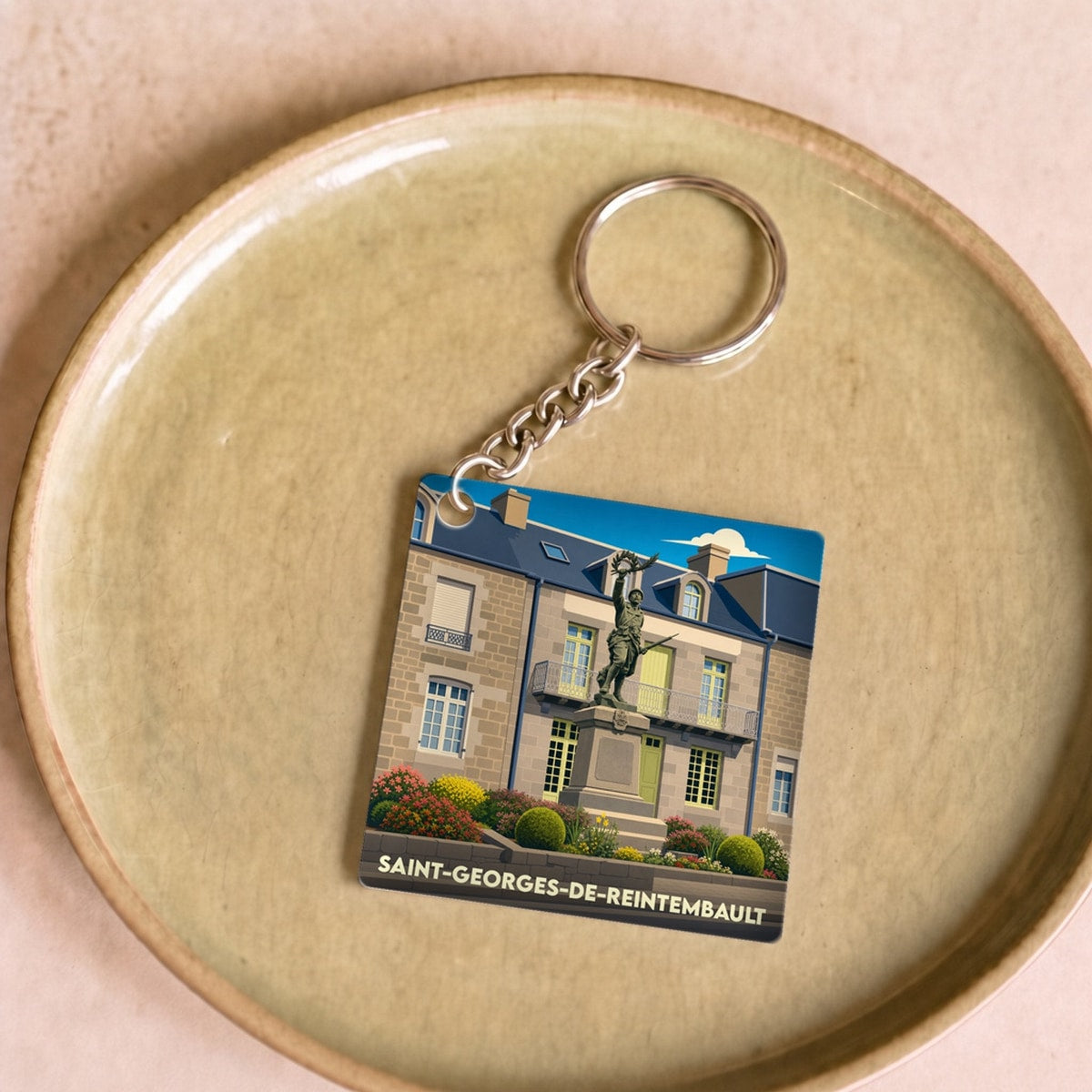 Porte-clés souvenir de la ville de Saint-Georges-de-Reintembault avec une illustration stylisée.