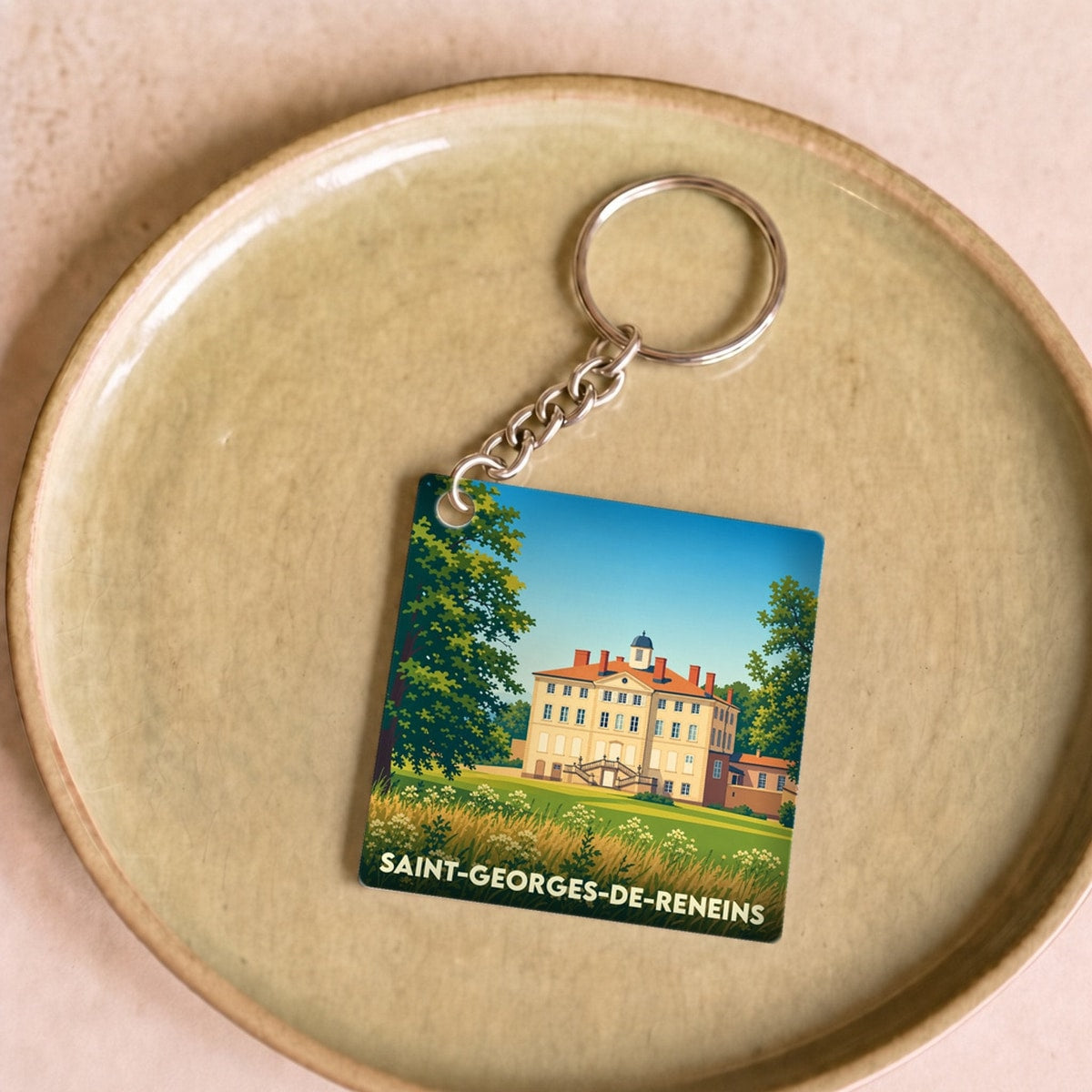 Porte-clés souvenir de la ville de Saint-Georges-de-Reneins avec une illustration stylisée d'un château.