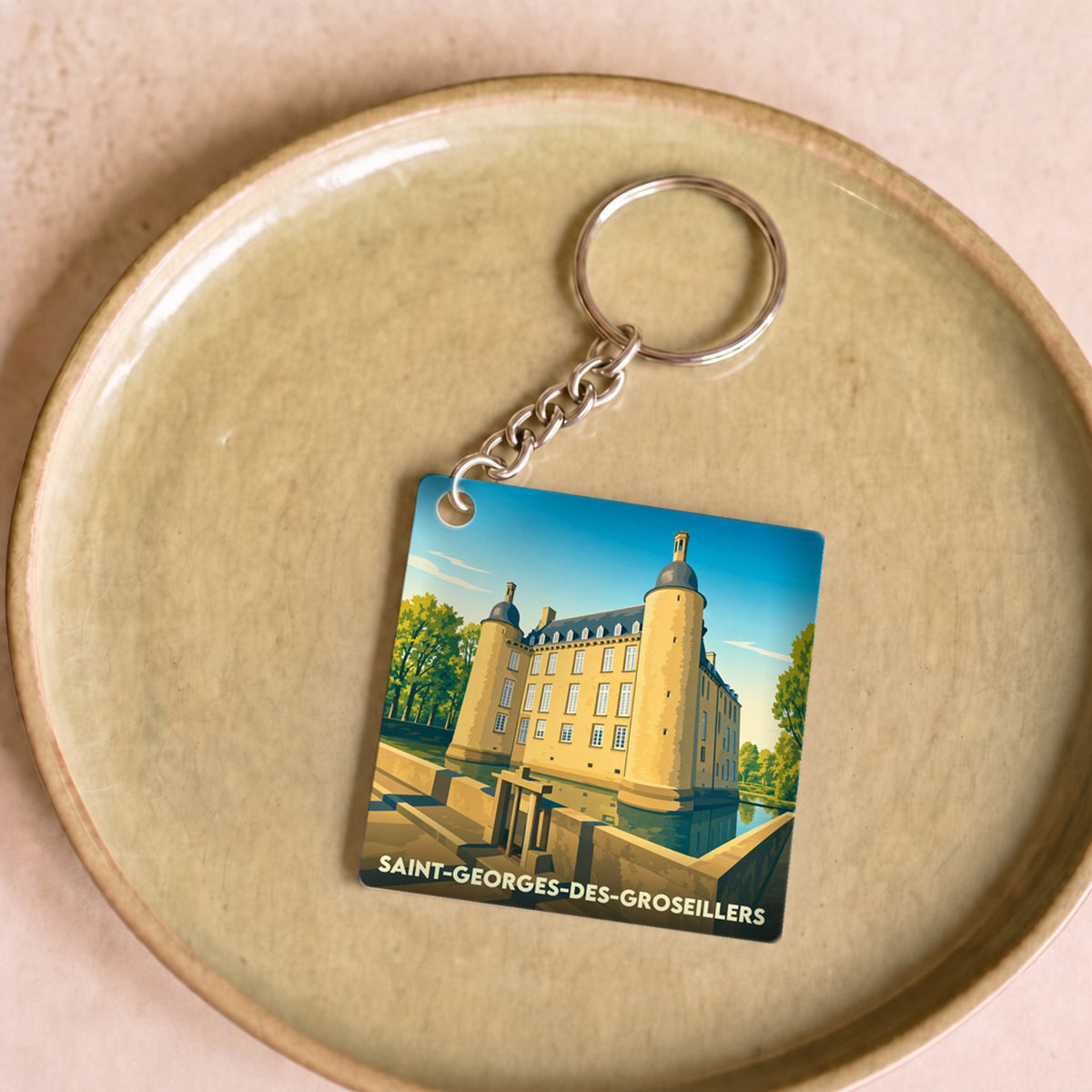 Porte-clés souvenir de la ville de Saint-Georges-des-Groseillers avec une illustration stylisée de son château.