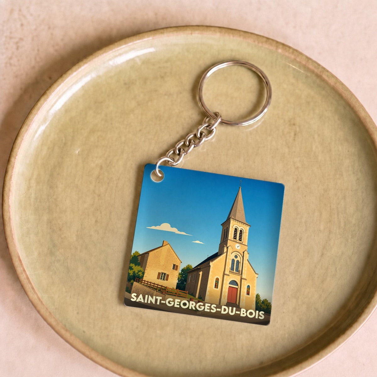 Porte-clés souvenir de la ville de Saint-Georges-du-Bois avec une illustration stylisée de son église.