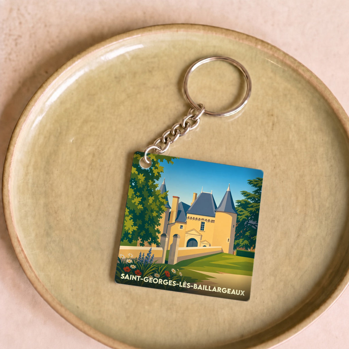 Porte-clés souvenir de la ville de Saint-Georges-lès-Baillargeaux avec une illustration stylisée d'un château.