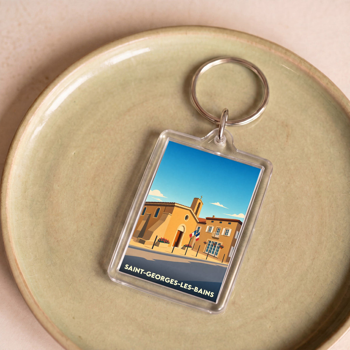 Porte-clés souvenir de la ville de Saint-Georges-les-Bains avec une illustration stylisée.