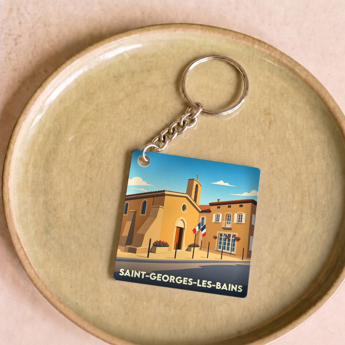 Porte-clés souvenir de la ville de Saint-Georges-les-Bains avec une illustration stylisée.