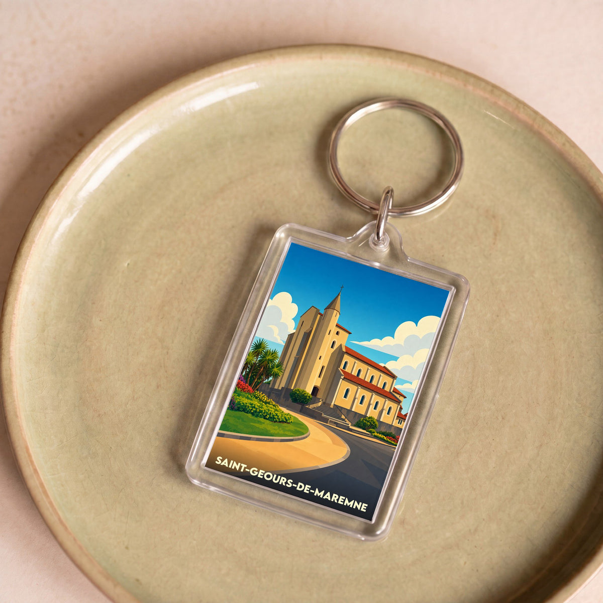 Porte-clés souvenir de la ville de Saint-Geours-de-Maremne avec une illustration stylisée de son église.