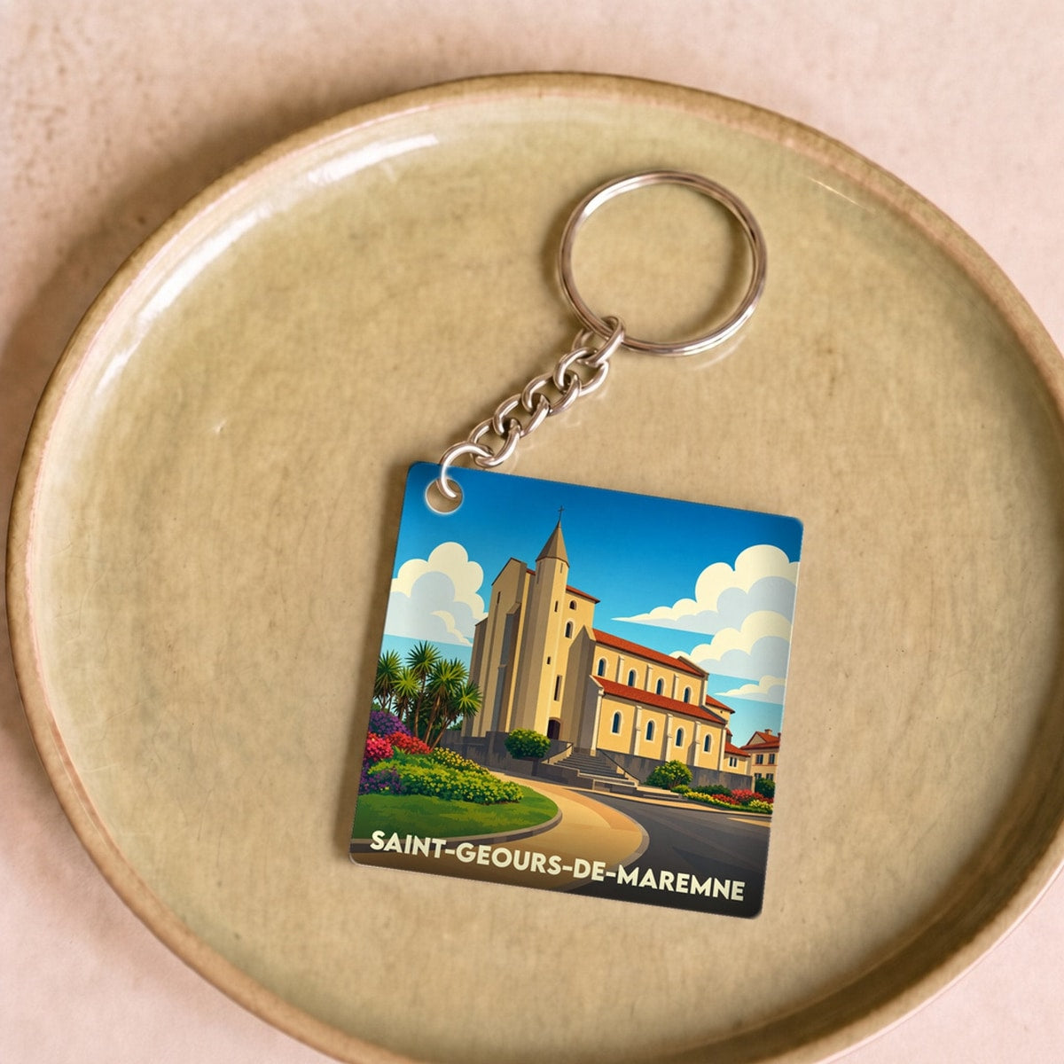 Porte-clés souvenir de la ville de Saint-Geours-de-Maremne avec une illustration stylisée de son église.