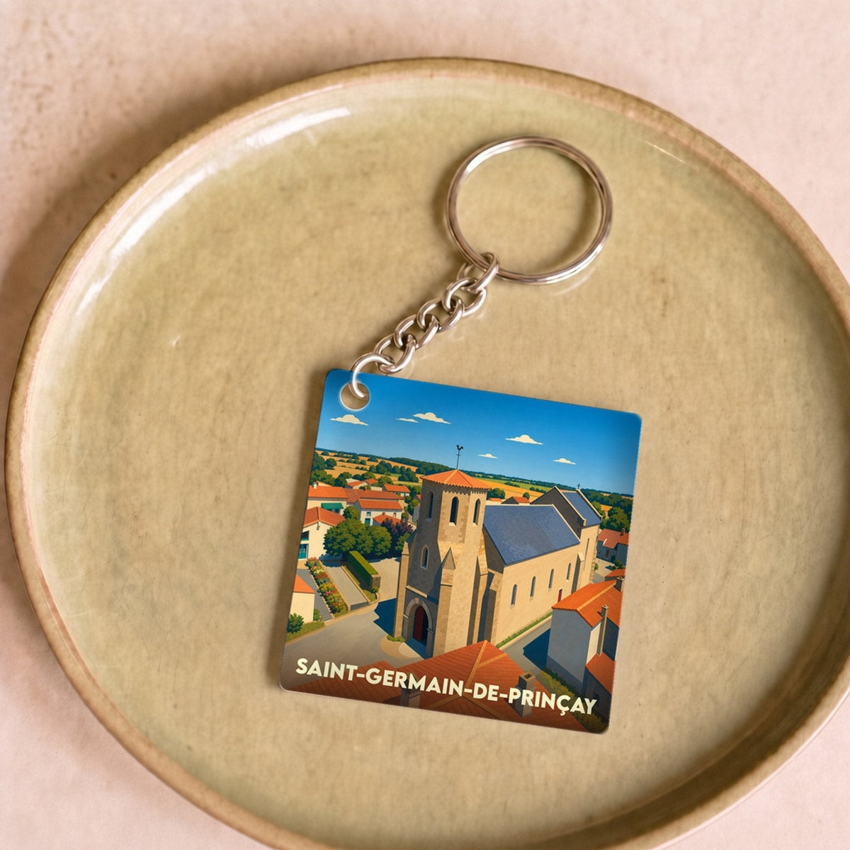 Porte-clés souvenir de la ville de Saint-Germain-de-Prinçay avec une illustration stylisée de son église.
