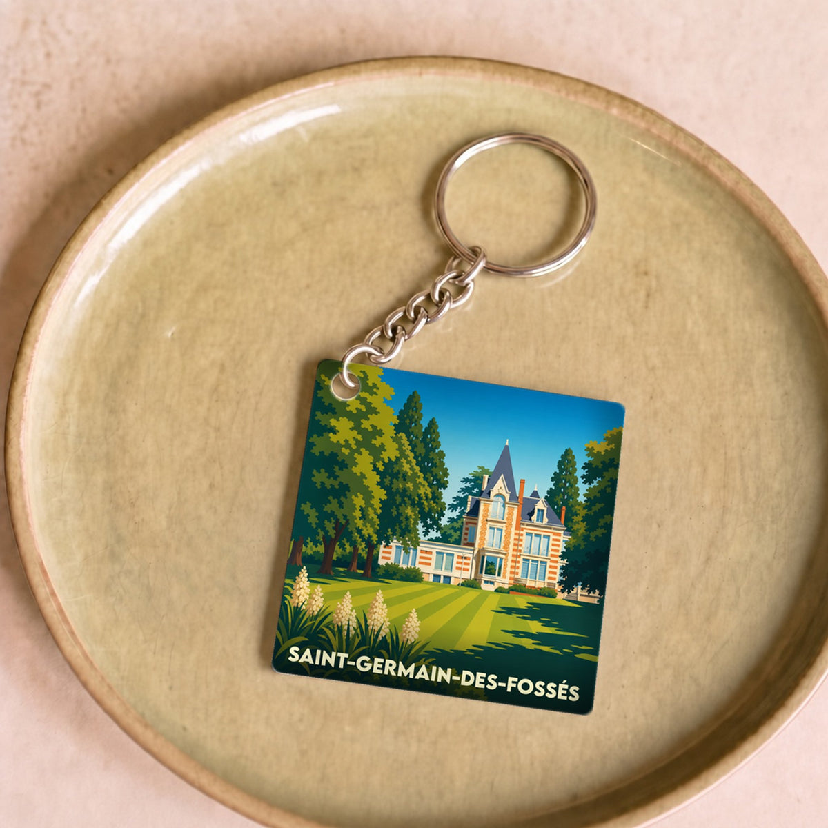 Porte-clés souvenir de la ville de Saint-Germain-des-Fossés avec une illustration stylisée.