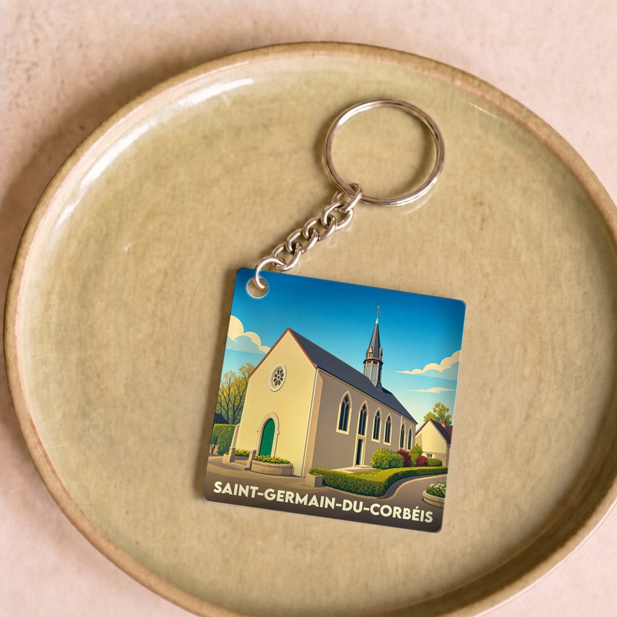 Porte-clés souvenir de la ville de Saint-Germain-du-Corbéis avec une illustration stylisée de son église.