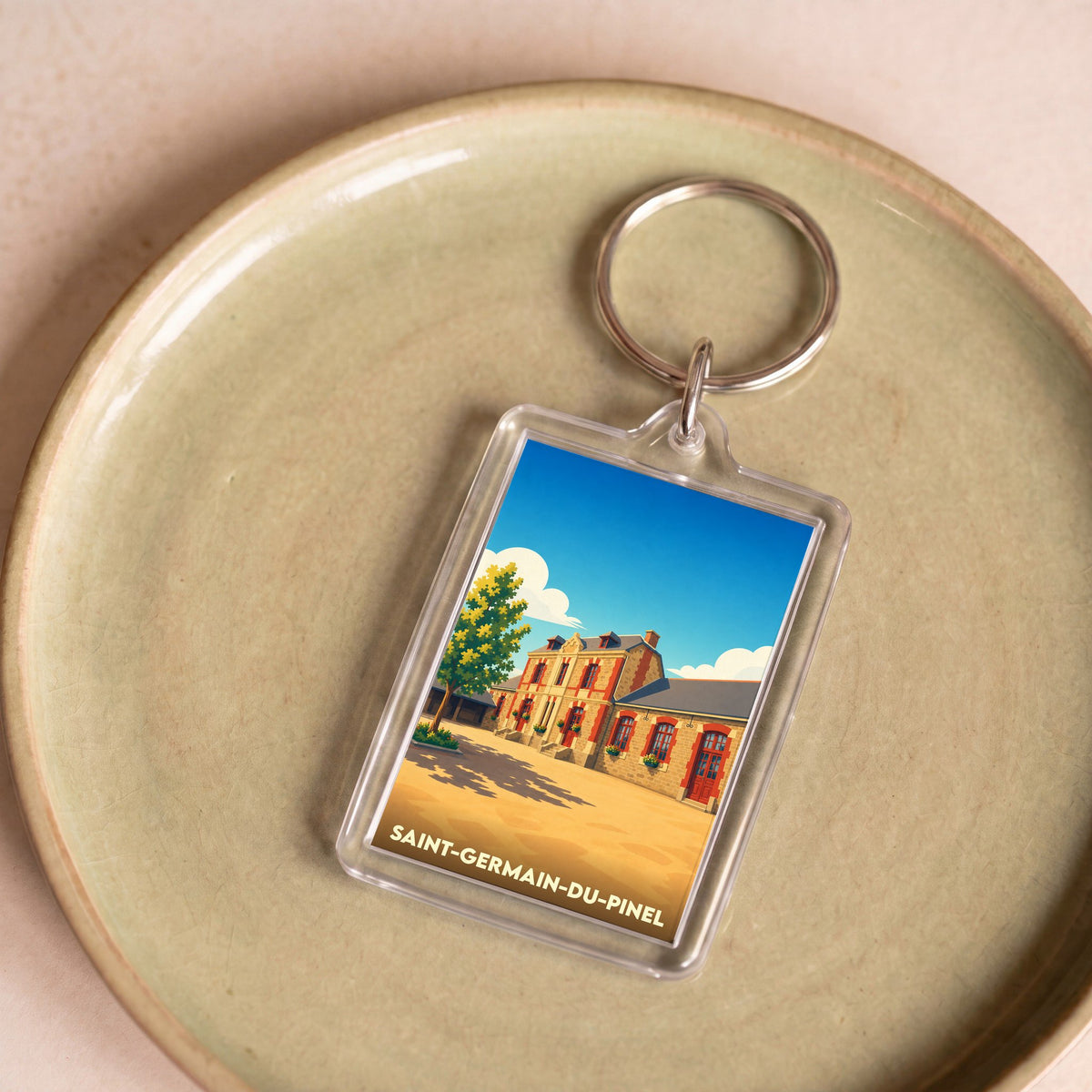 Porte-clés souvenir de Saint-Germain-du-Pinel avec une illustration stylisée.