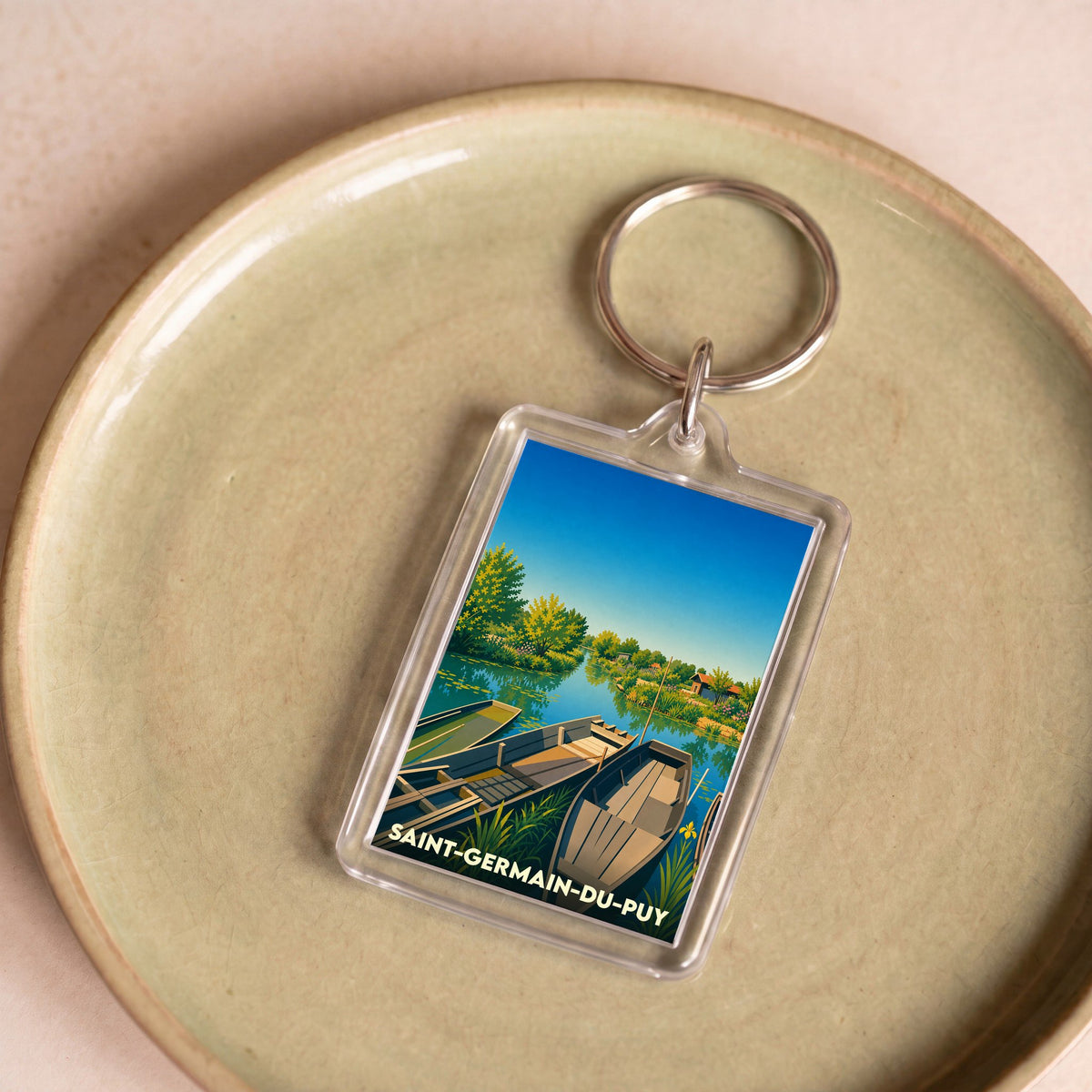 Porte-clés souvenir de la ville de Saint-Germain-du-Puy avec une illustration stylisée de barques sur l'eau.