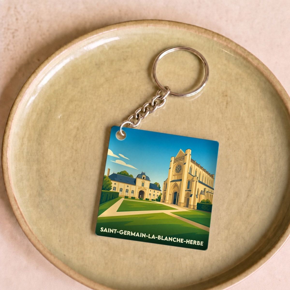 Porte-clés souvenir de la ville de Saint-Germain-la-Blanche-Herbe avec une illustration stylisée.