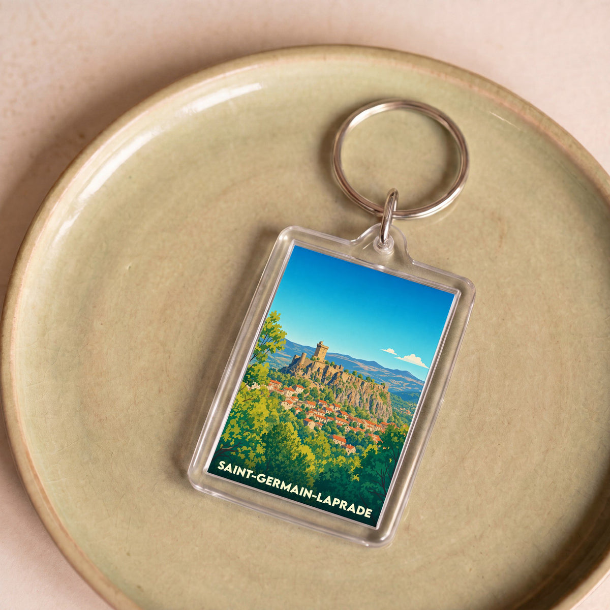 Porte-clés souvenir de la ville de Saint-Germain-Laprade avec une illustration stylisée d'un paysage médiéval.
