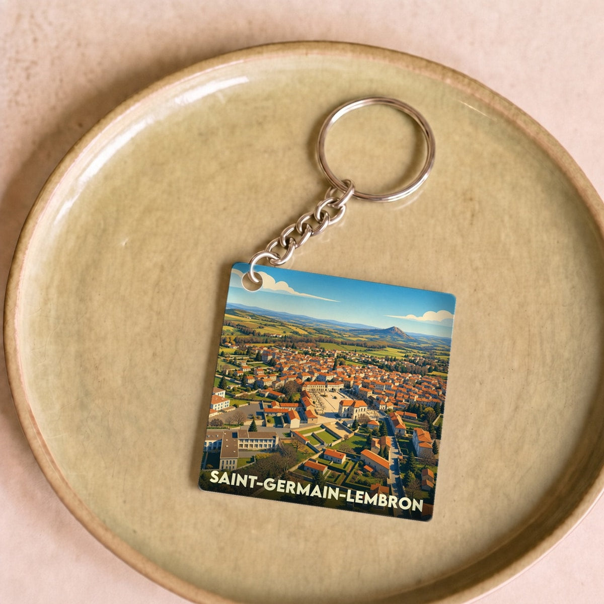 Porte-clés souvenir de la ville de Saint-Germain-Lembron avec une illustration stylisée.