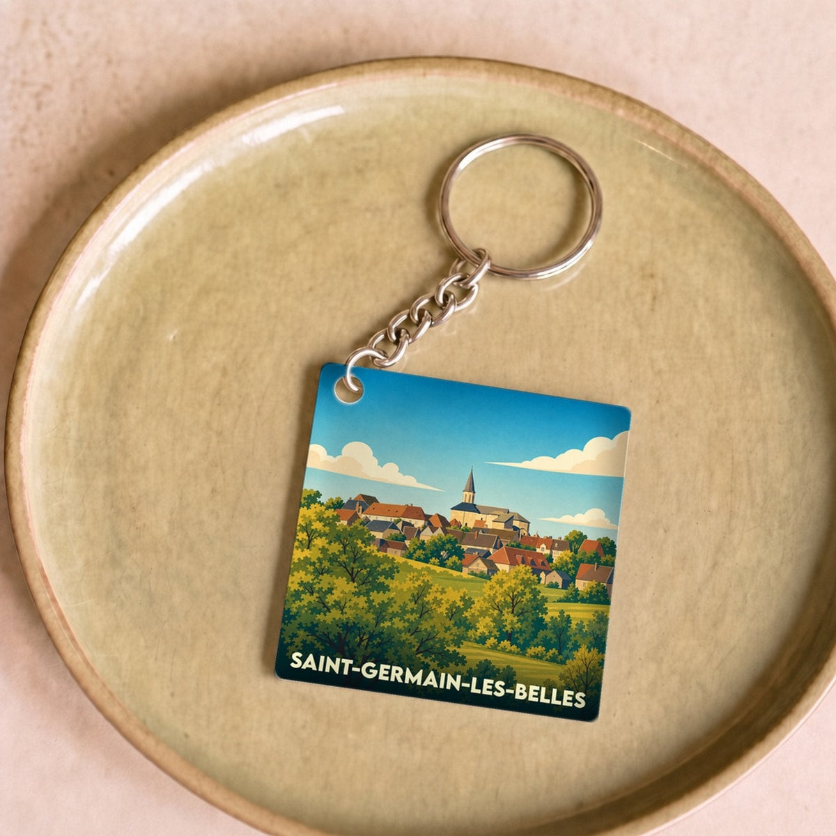 Porte-clés souvenir de la ville de Saint-Germain-les-Belles avec une illustration stylisée.