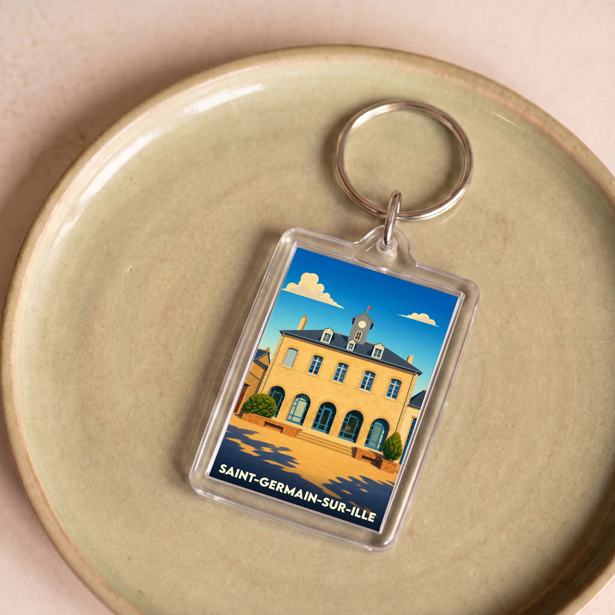 Porte-clés souvenir de la ville de Saint-Germain-sur-Ille avec une illustration stylisée.