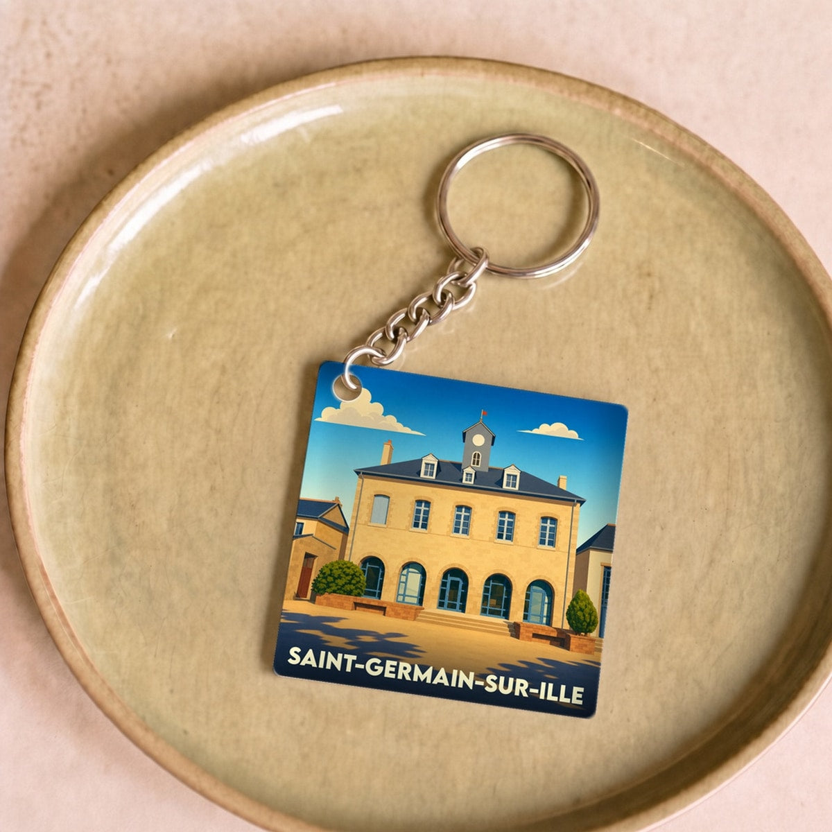 Porte-clés souvenir de la ville de Saint-Germain-sur-Ille avec une illustration stylisée.
