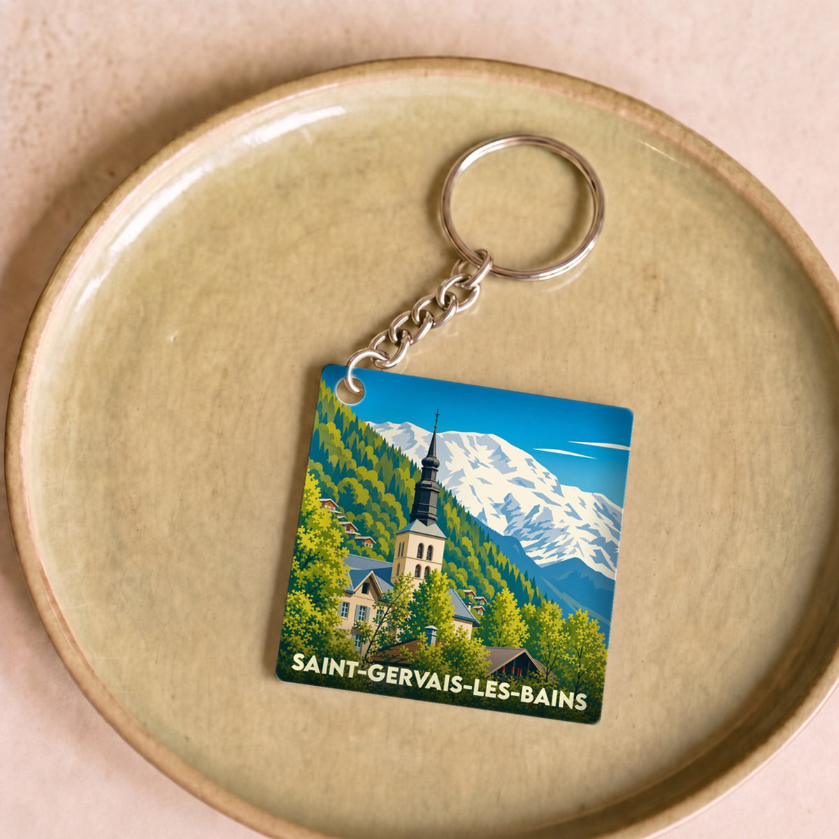 Porte-clés souvenir de la ville de Saint-Gervais-les-Bains avec une illustration stylisée de son église face au Mont-Blanc.