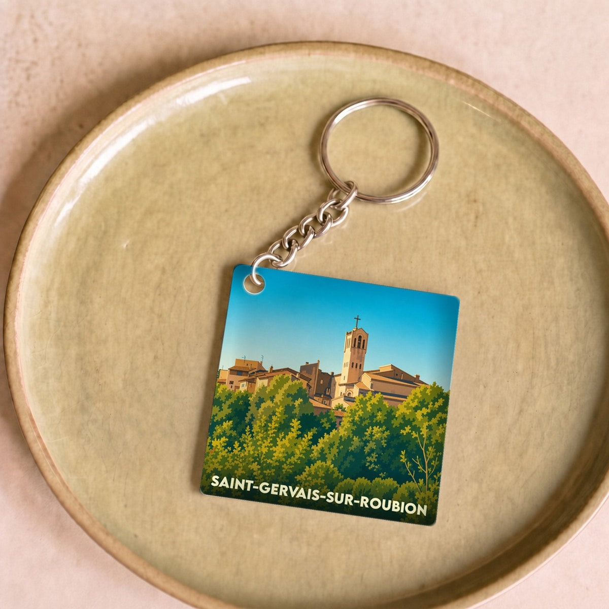 Porte-clés souvenir de la ville de Saint-Gervais-sur-Roubion avec une illustration stylisée.